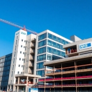 NHS hospital construction site with cranes and workers