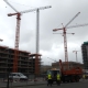 UK construction site with workers and cranes, subdued activity