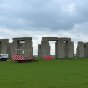 Stonehenge monument with construction barriers and equipment nearby.
