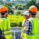 Construction workers in front of a green city skyline.