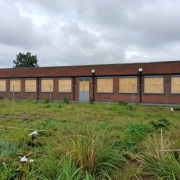 Former Rowley Regis Day Centre site with vacant lot and derelict building.