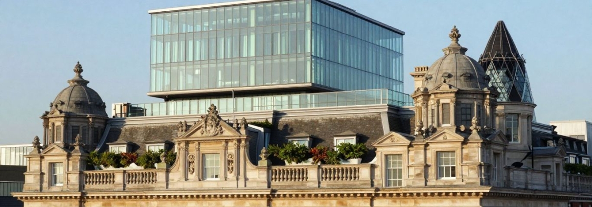Historic London building with modern rooftop hotel extension.